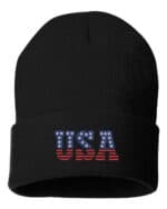Black cuffed beanie with "USA" in bold letters featuring an American flag pattern, showcasing patriotic style.