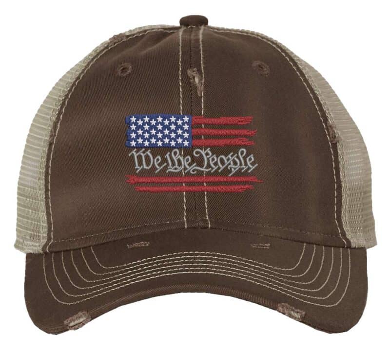 Distressed trucker hat with embroidered American flag and "We The People," ideal for showcasing patriotic pride in style.