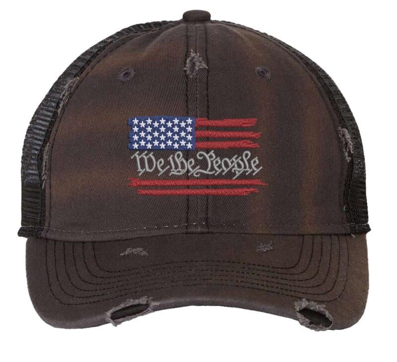 Distressed trucker hat with embroidered American flag and "We The People," ideal for showcasing patriotic pride in style.