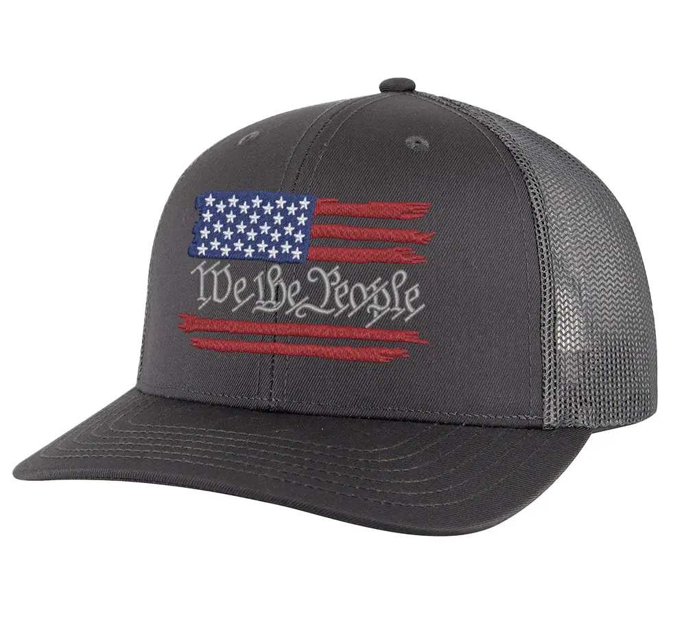 We The People Distressed American Flag Trucker Hat in gray with mesh back and embroidered flag design on the front.