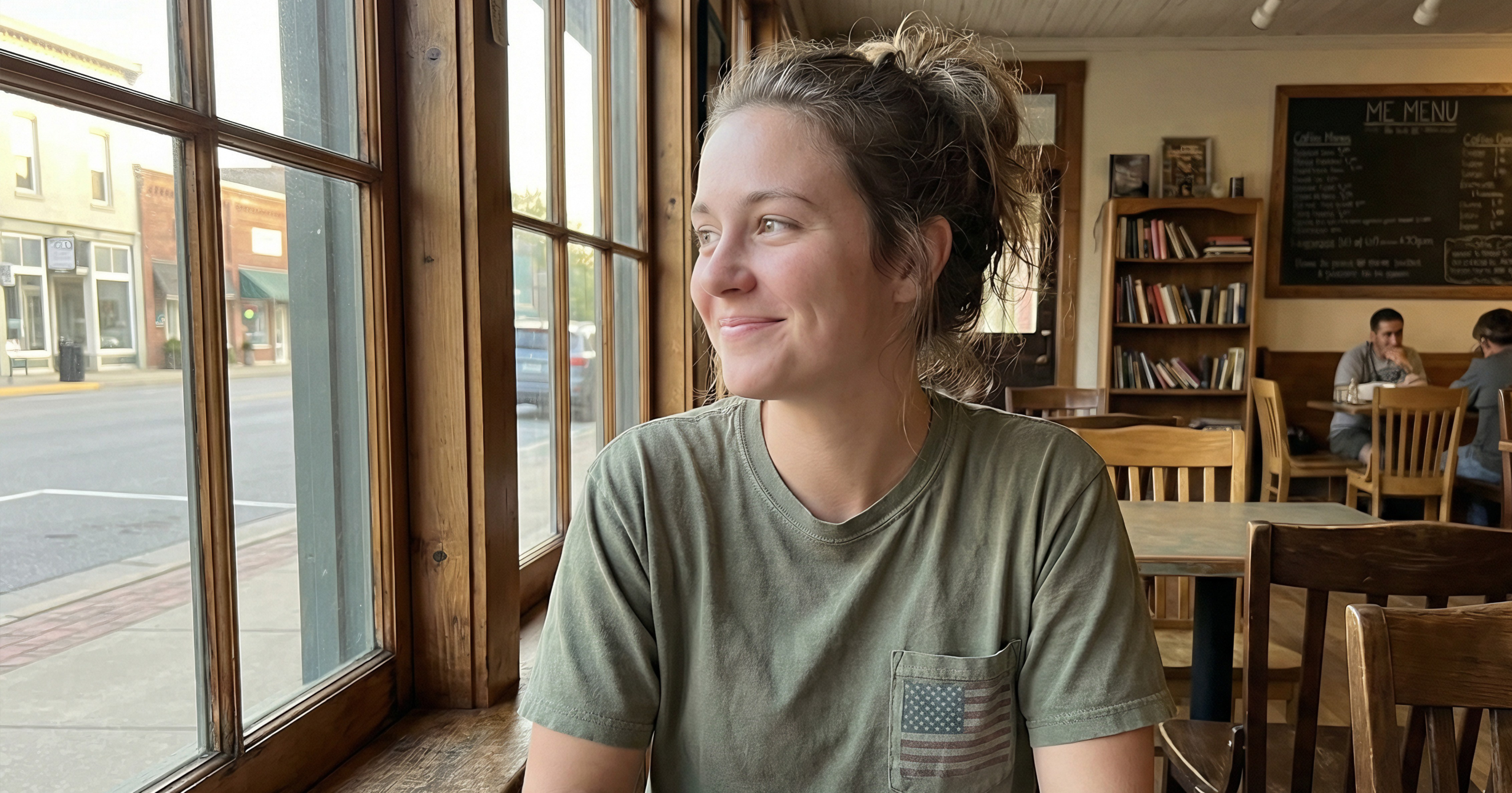 Girl sitting in coffee shop wearing patriotic tshirt with american flag