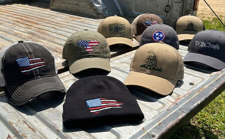 Trucker hats, baseball hats and beanies on pickup tailgate.