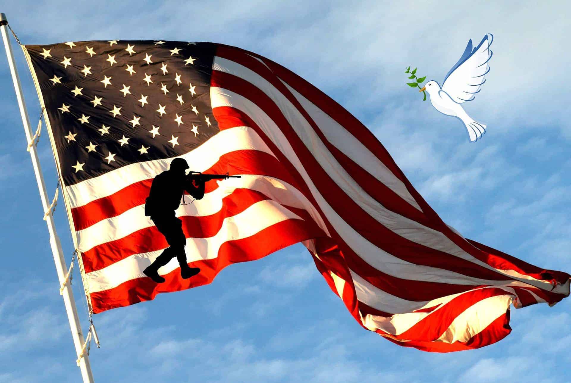 American flag with silhouette of soldier and flying dove in the sky.