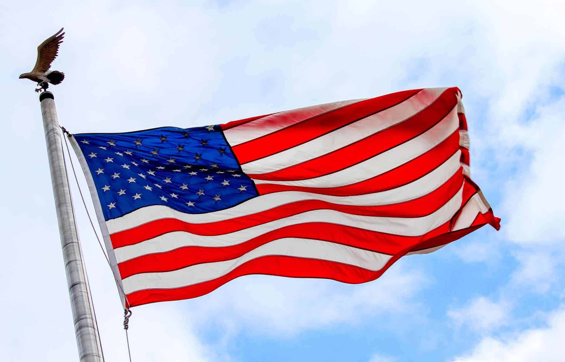 American flag waving in the wind against a blue sky.