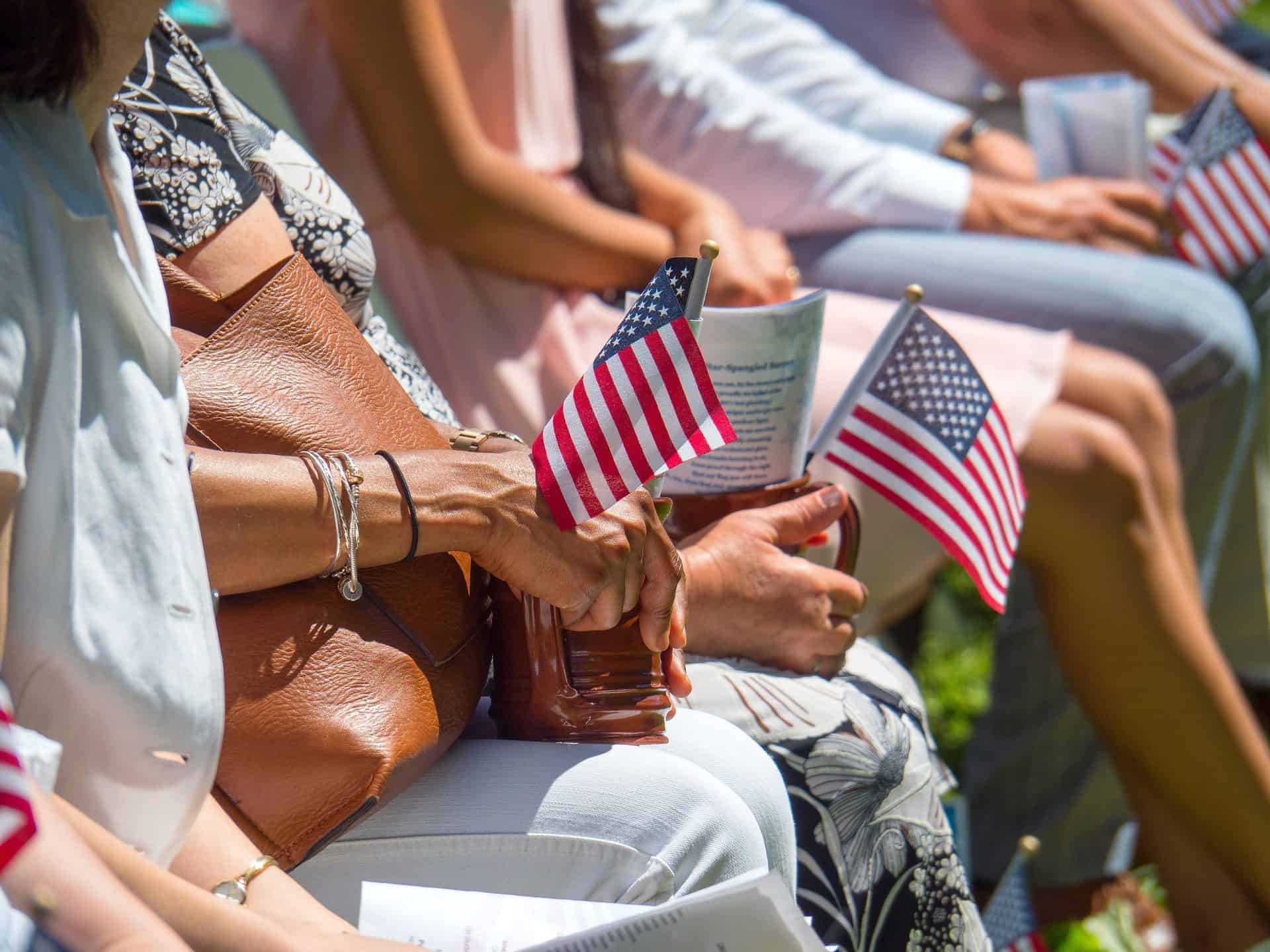 Group of people holding American flags at a patriotic event.