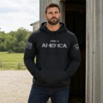 Man wearing black 'Made in America' hoodie outdoors on a farm.