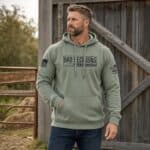 Man wearing a green distressed hoodie with 'Bad Decisions' print outdoors.