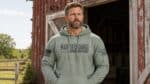 Man wearing Bad Decisions Supervisor Hoodie outdoors on a farm.
